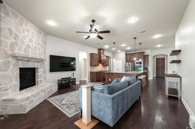 4416 Berry Ridge Ln, Frisco, TX 75036 - living room with arched walkways, a ceiling fan, dark wood-type flooring, a fireplace, and recessed lighting