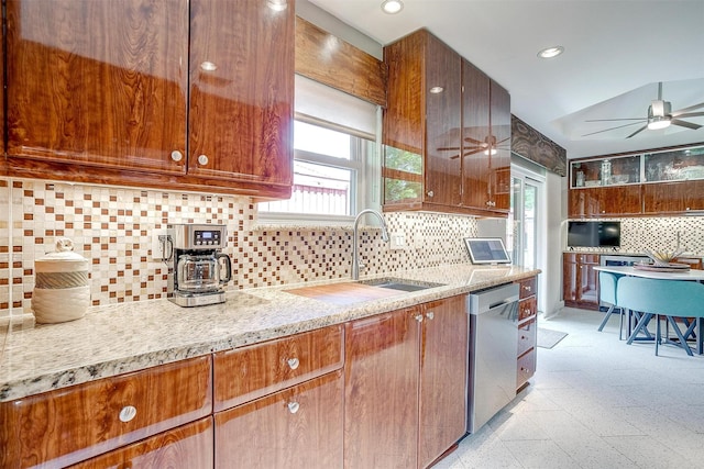 kitchen featuring dishwasher, decorative backsplash, a ceiling fan, a sink, and healthy amount of natural light
