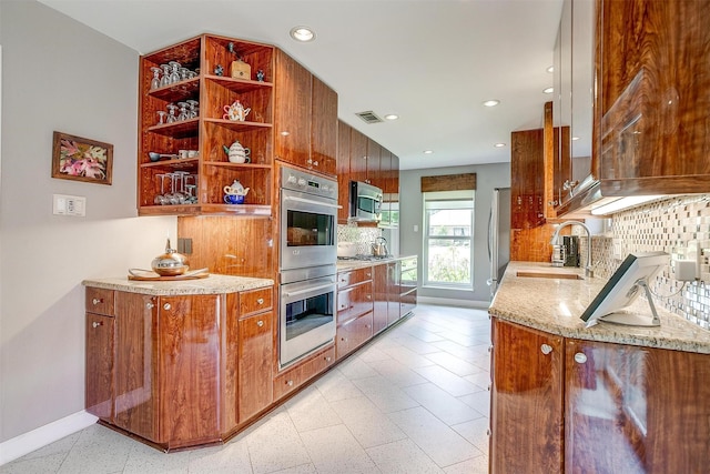 kitchen with appliances with stainless steel finishes, a sink, open shelves, baseboards, and backsplash