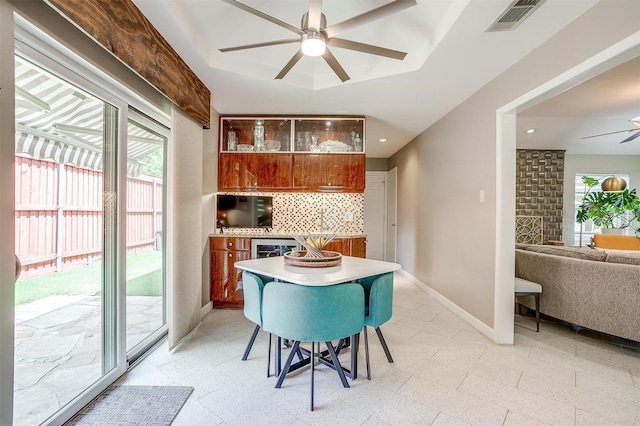 dining space with ceiling fan, baseboards, beverage cooler, and light flooring