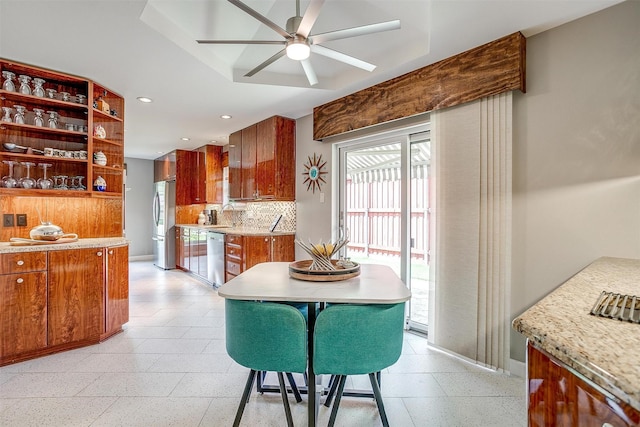 dining space featuring a ceiling fan, baseboards, recessed lighting, plenty of natural light, and dark aggregate flooring