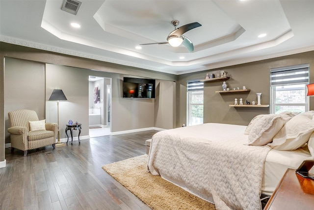 bedroom with a tray ceiling, baseboards, dark wood finished floors, recessed lighting, and ensuite bathroom