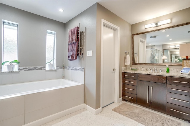 full bathroom with baseboards, a garden tub, vanity, and recessed lighting