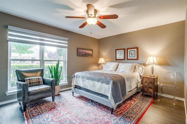 bedroom featuring wood finished floors, baseboards, and ceiling fan