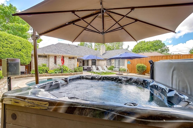 exterior space featuring a hot tub and fence