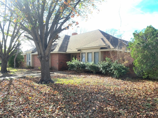 327 Trevino Trl, Lancaster, TX 75146 - view of home's exterior with brick siding, a chimney, and roof with shingles