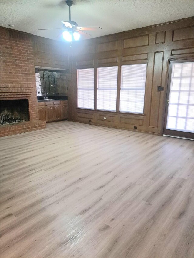 327 Trevino Trl, Lancaster, TX 75146 - unfurnished living room with wood finished floors, ceiling fan, healthy amount of natural light, and a brick fireplace