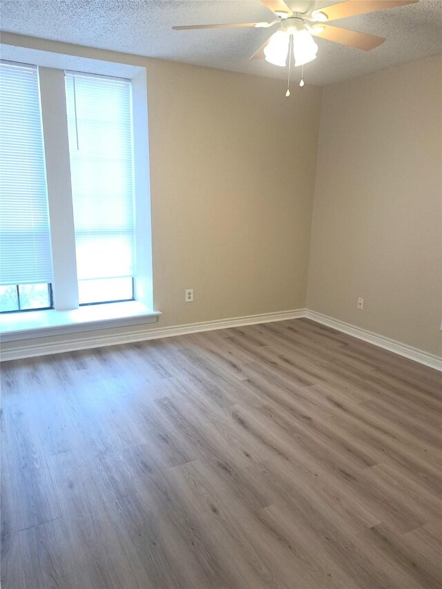327 Trevino Trl, Lancaster, TX 75146 - empty room with a ceiling fan, wood finished floors, baseboards, and a textured ceiling