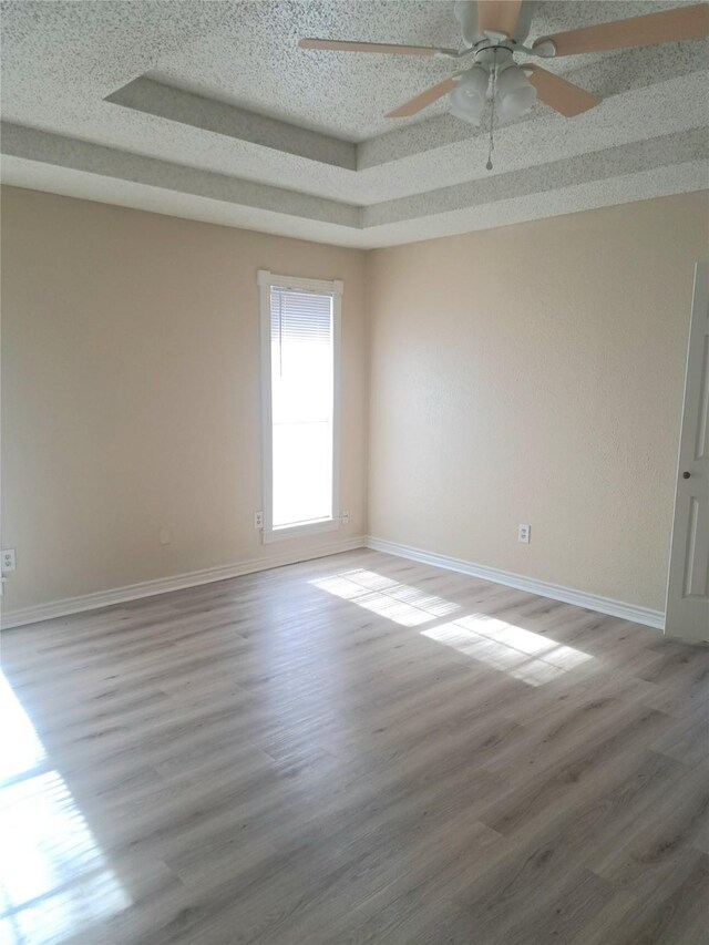 327 Trevino Trl, Lancaster, TX 75146 - empty room with wood finished floors, baseboards, ceiling fan, and a tray ceiling