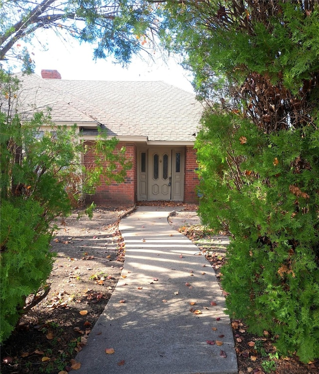 327 Trevino Trl, Lancaster, TX 75146 - doorway to property featuring a chimney, brick siding, and roof with shingles