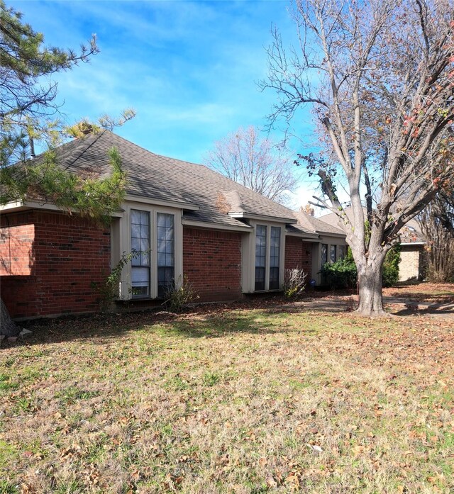 327 Trevino Trl, Lancaster, TX 75146 - back of property featuring brick siding, a lawn, and a shingled roof