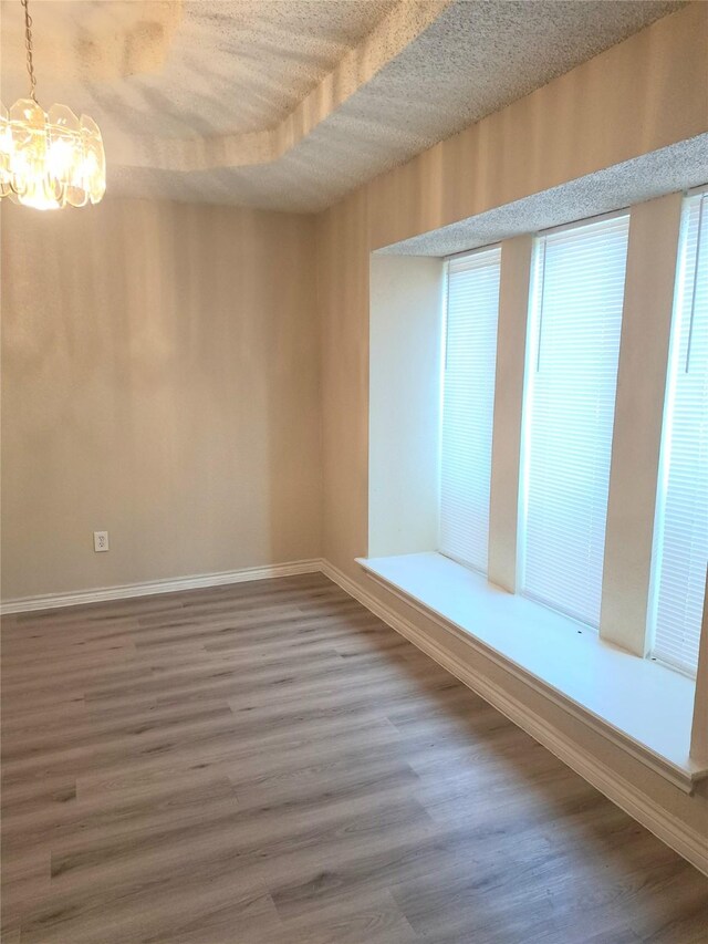 327 Trevino Trl, Lancaster, TX 75146 - empty room with a chandelier, wood finished floors, and baseboards
