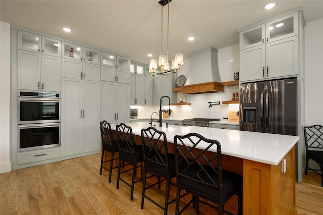105 Shawnee Trl, Pottsboro, TX 75076 - kitchen with appliances with stainless steel finishes, custom range hood, light wood-type flooring, light countertops, and recessed lighting