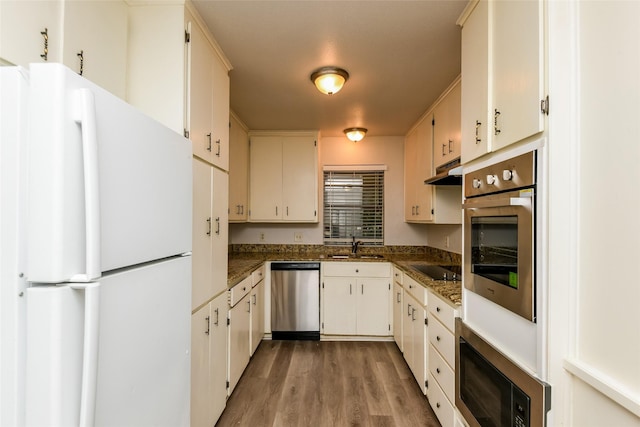 5304 Weddington Ct, Fort Worth, TX 76133 - kitchen featuring stainless steel appliances, dark countertops, under cabinet range hood, light wood-style floors, and a sink