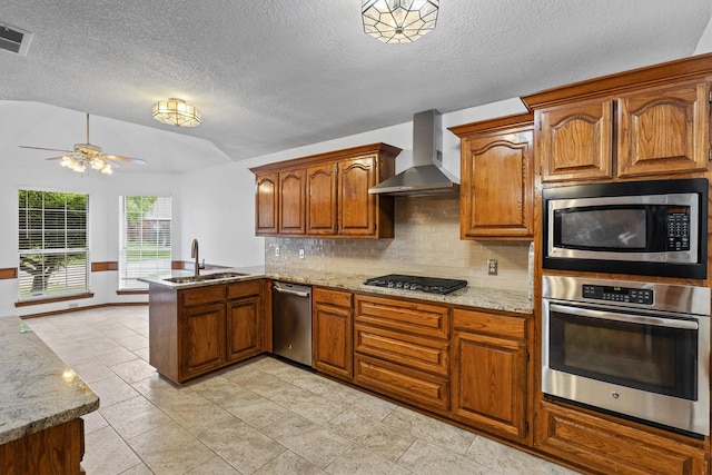 208 N Rustic Trl, Wylie, TX 75098 - kitchen featuring appliances with stainless steel finishes, a sink, a peninsula, wall chimney range hood, and vaulted ceiling