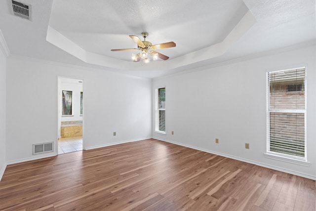 208 N Rustic Trl, Wylie, TX 75098 - spare room featuring a tray ceiling, hardwood / wood-style floors, ceiling fan, baseboards, and ornamental molding
