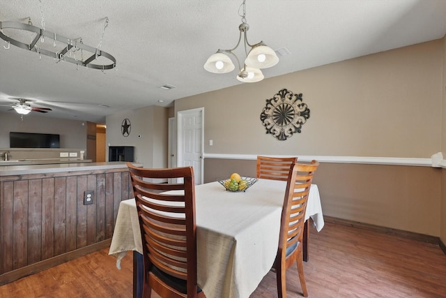 1554 Brandywine Ln, Little Elm, TX 75068 - dining room featuring wood finished floors, a ceiling fan, a textured ceiling, and baseboards