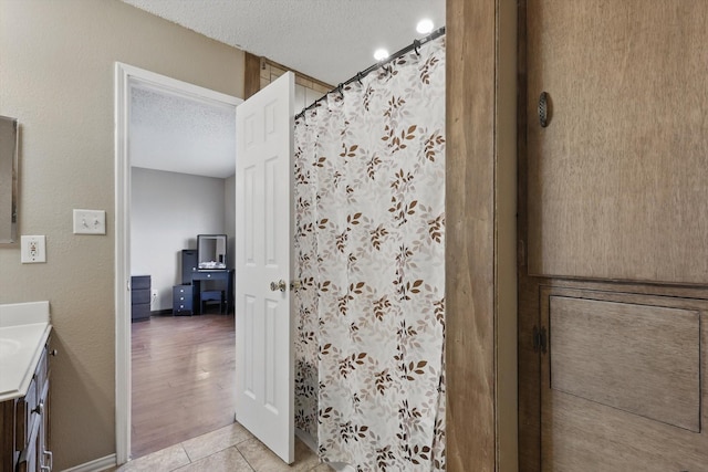 1554 Brandywine Ln, Little Elm, TX 75068 - full bath with a textured ceiling, vanity, a shower with shower curtain, and tile patterned floors
