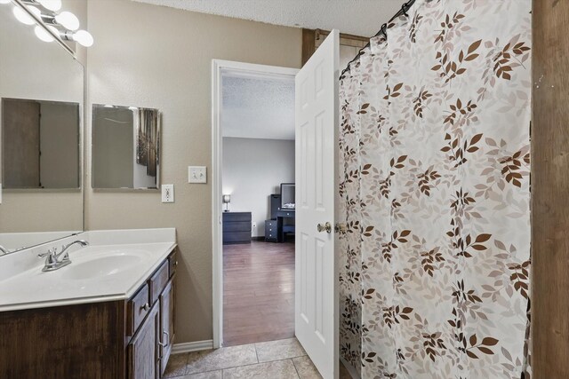 1554 Brandywine Ln, Little Elm, TX 75068 - bathroom featuring a textured ceiling, vanity, baseboards, tile patterned flooring, and a shower with curtain