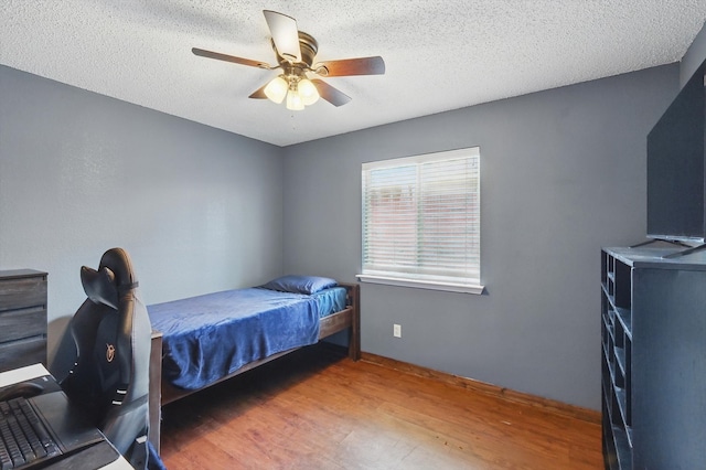 1554 Brandywine Ln, Little Elm, TX 75068 - bedroom with wood finished floors, ceiling fan, baseboards, and a textured ceiling
