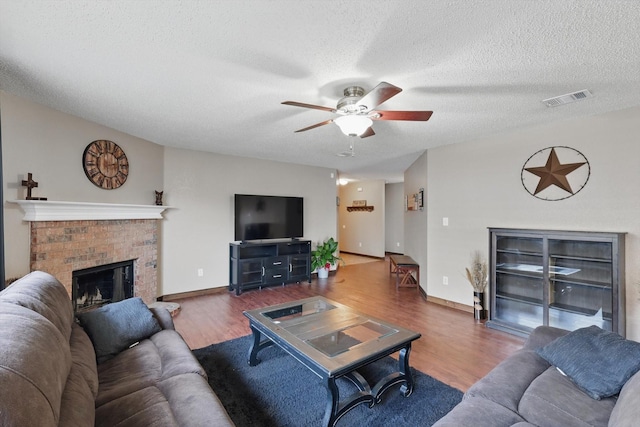 1554 Brandywine Ln, Little Elm, TX 75068 - living room with a fireplace, ceiling fan, wood finished floors, a textured ceiling, and baseboards