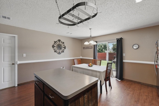 1554 Brandywine Ln, Little Elm, TX 75068 - dining room featuring a chandelier, dark wood finished floors, a textured ceiling, and baseboards