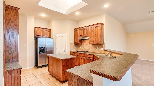 10252 Red Bluff Ln, Fort Worth, TX 76177 - kitchen featuring stainless steel appliances, under cabinet range hood, a peninsula, a center island, and decorative backsplash