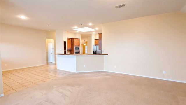 10252 Red Bluff Ln, Fort Worth, TX 76177 - kitchen with stainless steel appliances, light tile patterned floors, recessed lighting, open floor plan, and light colored carpet