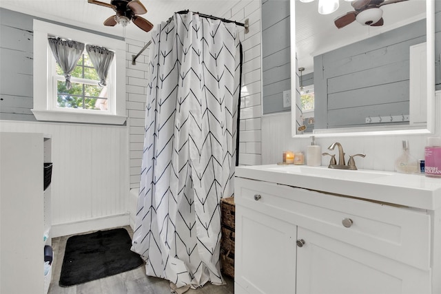820 W Gandy St, Denison, TX 75020 - bathroom with a ceiling fan, vanity, a shower with curtain, wood walls, and wood finished floors