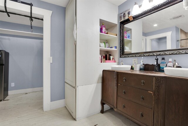 820 W Gandy St, Denison, TX 75020 - bathroom with vanity, wood finished floors, and baseboards