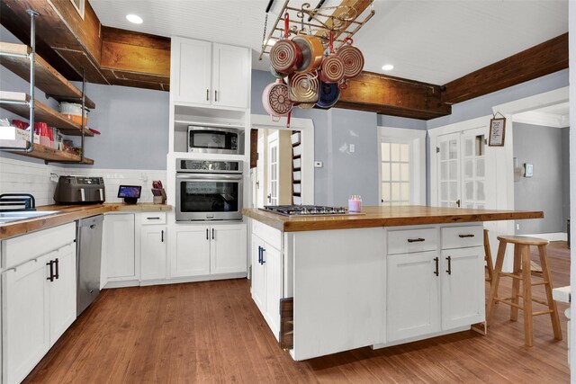 820 W Gandy St, Denison, TX 75020 - kitchen featuring appliances with stainless steel finishes, recessed lighting, butcher block counters, wood finished floors, and tasteful backsplash