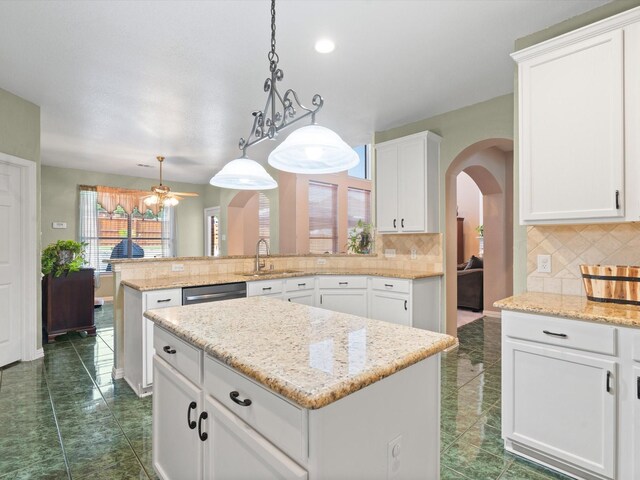 2105 Indian Trl, Rowlett, TX 75088 - kitchen with a peninsula, arched walkways, dark tile patterned floors, backsplash, and dishwasher