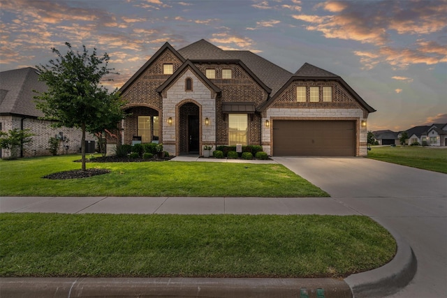 1037 Mickelson Dr, Granbury, TX 76048 - french country home with concrete driveway, a front yard, stone siding, and central air condition unit