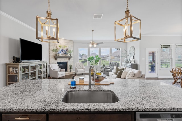 1037 Mickelson Dr, Granbury, TX 76048 - kitchen featuring a sink, a chandelier, open floor plan, ornamental molding, and dark brown cabinetry