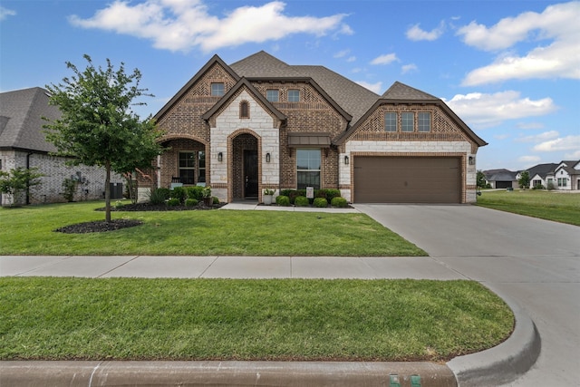 1037 Mickelson Dr, Granbury, TX 76048 - french country home with driveway, a front yard, stone siding, central air condition unit, and brick siding