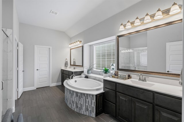 1037 Mickelson Dr, Granbury, TX 76048 - full bath with a stall shower, two vanities, lofted ceiling, a garden tub, and baseboards