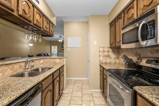 14333 Preston Rd Unit 2403, Dallas, TX 75254 - kitchen with appliances with stainless steel finishes, a sink, backsplash, ceiling fan, and light stone countertops