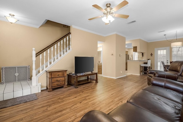 14333 Preston Rd Unit 2403, Dallas, TX 75254 - living room with light wood-style flooring, ornamental molding, ceiling fan, stairs, and baseboards
