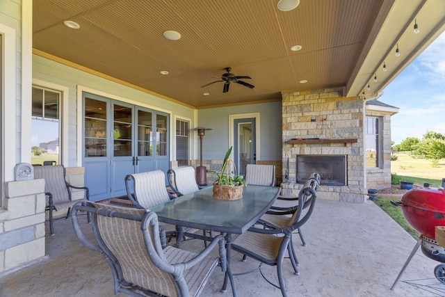 1206 Jc Maples Rd, Gunter, TX 75058 - view of patio / terrace with an outdoor stone fireplace, outdoor dining space, ceiling fan, and area for grilling