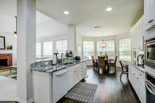 1016 S Hollow Dr, Southlake, TX 76092 - kitchen featuring stainless steel appliances, a sink, white cabinets, light stone counters, and recessed lighting