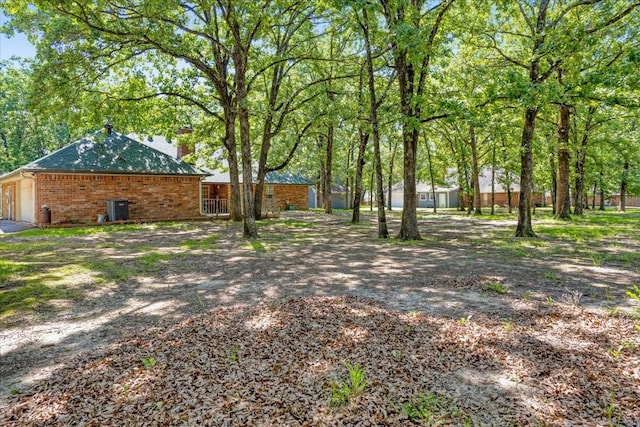 607 Dogwood Cir, Powderly, TX 75473 - view of yard with an attached garage and cooling unit