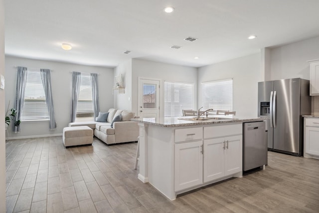 8580 Big Apple Dr, Fort Worth, TX 76179 - kitchen with stainless steel appliances, a sink, light wood-type flooring, open floor plan, and a kitchen island with sink
