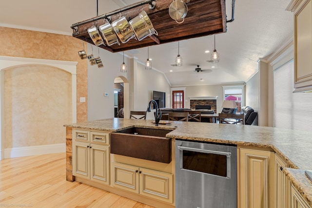 118 Lightning Trl, Forney, TX 75126 - kitchen featuring cream cabinets, a sink, a ceiling fan, arched walkways, and light wood finished floors