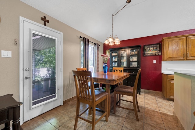 dining room featuring lofted ceiling, light tile patterned flooring, and a chandelier