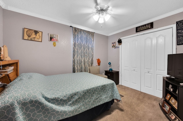 bedroom featuring carpet flooring, ornamental molding, a closet, a ceiling fan, and a textured ceiling