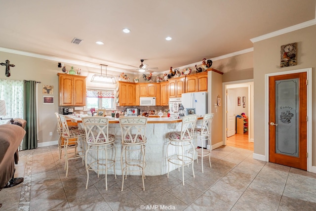 1302 County Road 142, Ovalo, TX 79541 - kitchen with white appliances, ornamental molding, a kitchen breakfast bar, ceiling fan, and light countertops
