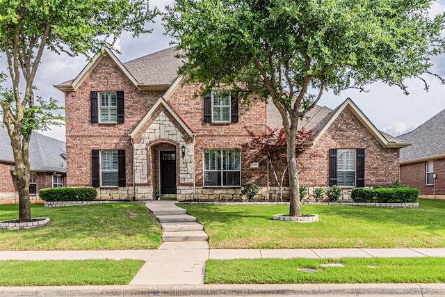 15097 Blakehill Dr, Frisco, TX 75035 - view of front facade with brick siding, a front yard, a shingled roof, and stone siding