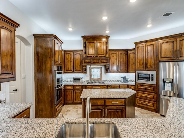 1141 Saint Peter Ln, Prosper, TX 75078 - kitchen with stainless steel appliances, tasteful backsplash, light stone countertops, and recessed lighting