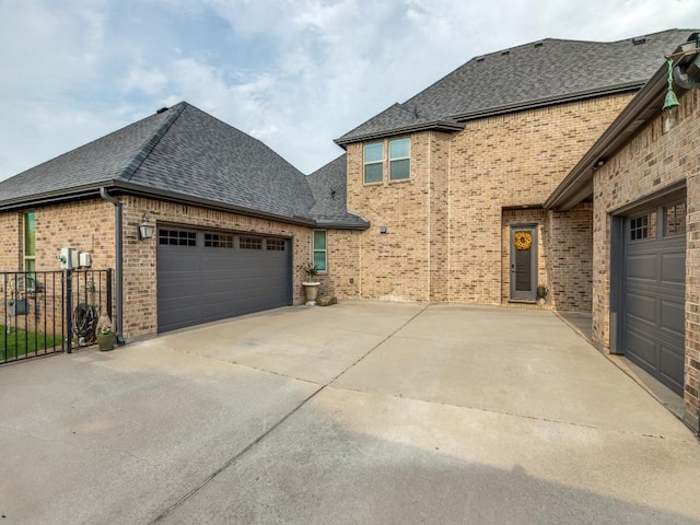 1141 Saint Peter Ln, Prosper, TX 75078 - view of side of home featuring a shingled roof, an attached garage, driveway, and brick siding