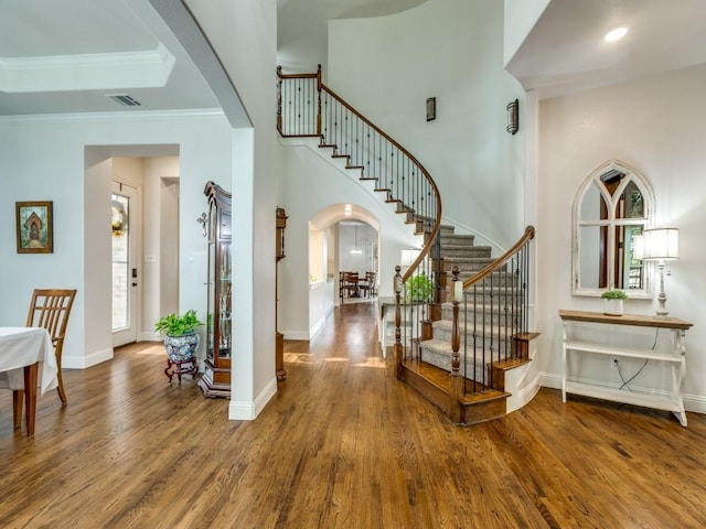 1141 Saint Peter Ln, Prosper, TX 75078 - foyer entrance featuring arched walkways, wood finished floors, stairway, crown molding, and a high ceiling